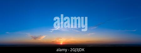 Cloudless sunrise sunset, orange light on a blue panorama background. Stock Photo