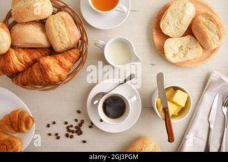 Morning coffee on a white wooden table with plate with two croissants and bread with isolated white background. Front view. Horizontal composition. Stock Photo