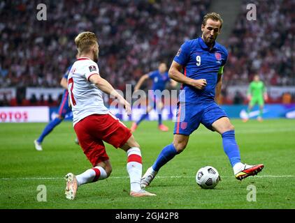 England's Harry Kane (right) and Poland's Kamil Jozwiak battle for the ball during the 2022 FIFA World Cup Qualifying match at PGE Narodowy Stadium, Warsaw. Picture date: Wednesday September 8, 2021. Stock Photo