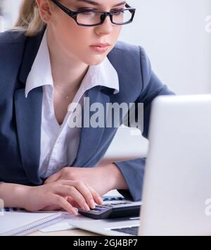The female finance professional working on keyboard with reports Stock Photo