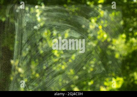 Dirty glass surface. The texture of the dust on the window. The view behind the cloudy glass. Stains on the window after washing with detergent. Clean Stock Photo