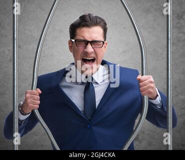 The young businessman behind the bars in prison Stock Photo