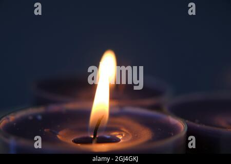 Burning candles.Candle flame.Set candles in the dark.Religion symbol. Candles background.Blue candles on blue background Stock Photo