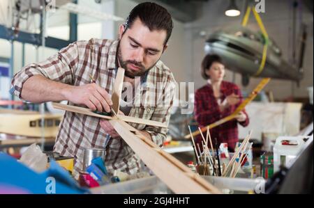 Glad man working on creating of airplane models Stock Photo