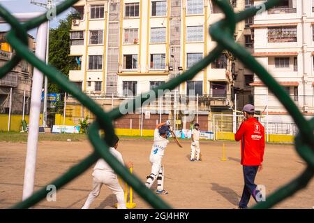 Game,practice,boys,playing ,cricket,under Coach,in red coat,at sreebhumi park,playground,Kolkata,India Stock Photo