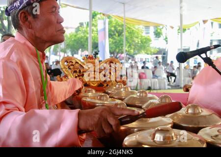 A bonang musician, one of the gamelan musical instruments, is accompanying a Palembang shadow puppet show or wayang kulit Palembang. Stock Photo