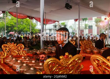 A bonang musician or player, one of the gamelan musical instruments, is accompanying a Javanese shadow puppet show. Stock Photo