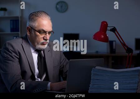 Old employee working late in the office Stock Photo