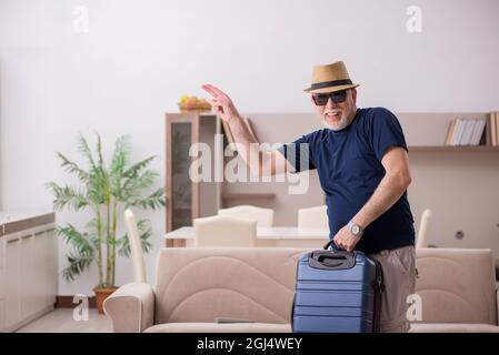 Old male tourist preparing for trip at home Stock Photo