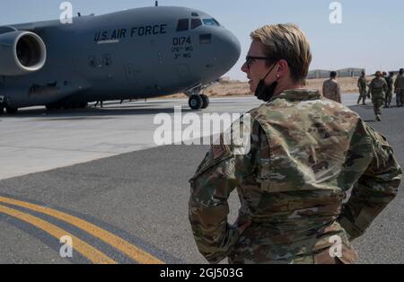 U.S. Air Force Master Sgt. Kathryn Murray, assigned to the 386th Expeditionary Logistics Readiness Squadron, awaits the deboarding of Afghanistan evacuees at Ali Al Salem Air Base, Kuwait, August 23, 2021. U.S. Air Force Airmen are assisting with evacuations of Americans and allied civilian personnel from Afghanistan. (U.S. Air Force Photo by Staff Sgt. Daryn Murphy) Stock Photo