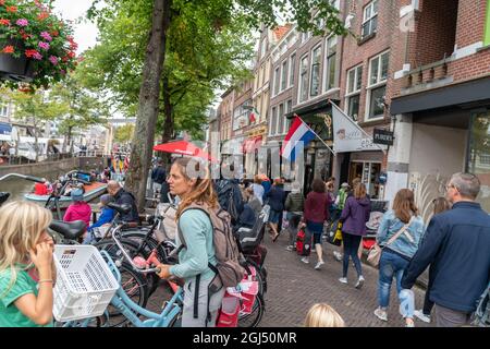 Alkmaar Netherlands - August 18 2012; Busy street crowded with tourists walking and at cafes in picturesque town Alkmaar of historic monuments and poi Stock Photo