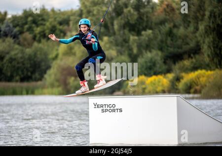 Wakeboarder making tricks. Low angle shot of man wakeboarding on a lake. Stock Photo