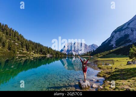 woman enjoying beauty of nature looking at mountain. Adventure travel, Europe. Woman stands on background with Alps. Stock Photo
