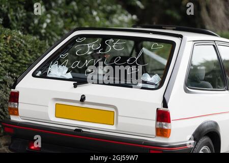 Just married sign hand written in classic old car windscreen with love heart for bride and groom after wedding ceremony Stock Photo