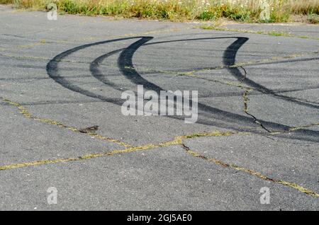 Black traces of car tires on the asphalt. Curved traces of burnt Stock Photo