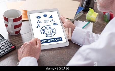 Workflow concept shown on a tablet held by a man Stock Photo