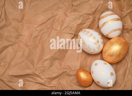 Golden Easter eggs on craft paper background. Trendy Easter flat lay composition. Copy space for text. Minimal Easter concept. Happy Easter day greeti Stock Photo