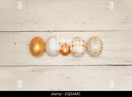 Golden Easter eggs on rustic old wooden background. Trendy Easter flat lay composition. Copy space for text. Minimal Easter concept. Happy Easter day Stock Photo