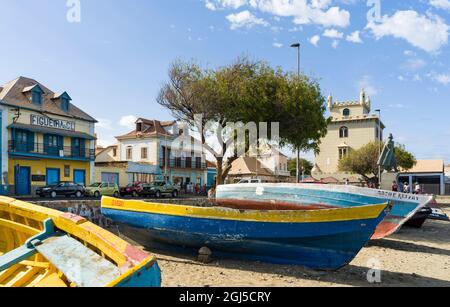 Traditional fishing boats on the beach of the harbor, landmark Torre de Belem in the background. City Mindelo, a seaport on the island Sao Vicente, Ca Stock Photo