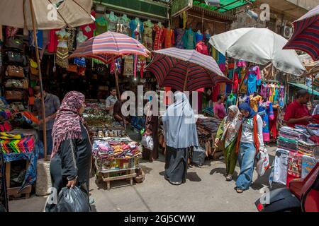 A busy section of the Khan el-Khalili Bazaar at Cairo in Egypt selling souvenirs, bags and clothing. Stock Photo