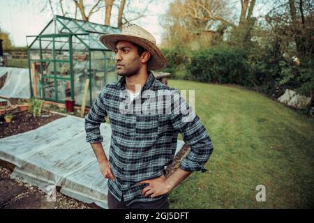 Mixed race male farmer working in greenhouse Stock Photo