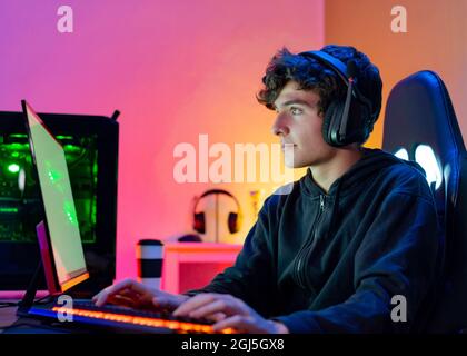 Teenager playing video game on computer Stock Photo