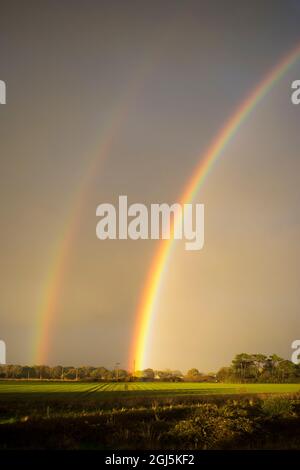 Double rainbow in stormy sky over Rook Farm,Hayling Island, Hampshire UK Stock Photo