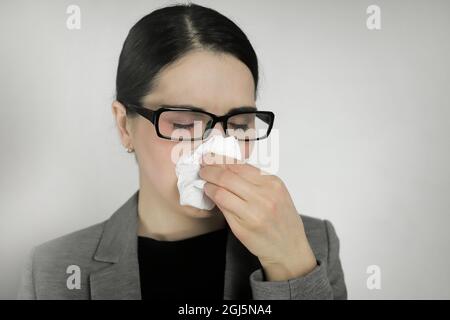 Young woman wearing glasses with flu symptoms. Stock Photo