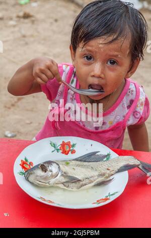 CHILD EATING FISH Stock Photo - Alamy
