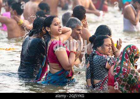 India, Uttar Pradesh, Allahabad, Prayagraj, Ardh Kumbh Mela. Pilgrims dip in the sacred waters of the Ganges River, believing that this will atone for Stock Photo