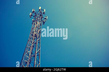 Telecom mast or Telecommunication mast TV antennas wireless technology with blue sky background, Show telecom tower infrastructure. Vintage concept Stock Photo