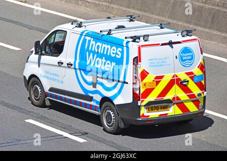 Thames Water van close up back & side view of white with blue logos driving on UK motorway high visibility reflective rear safety stripes England UK Stock Photo