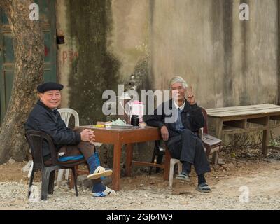 Asia, Vietnam, Tho Ha village. Men having tea at a small sidewalk cafe. (Editorial Use Only) Stock Photo