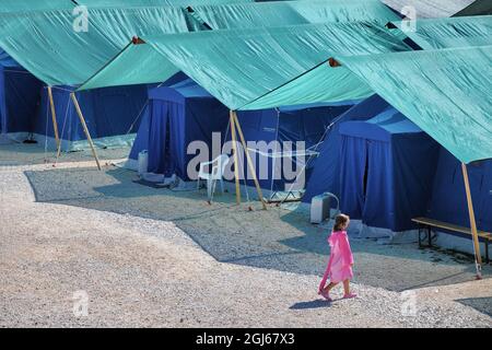 AQUILA, ITALY - Apr 12, 2018: The earthquake refugees tent camp with lonely child walking. Aquila, Italy. Stock Photo