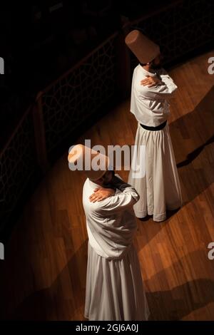 Konya - October 05, 2021: Whirling Dervish | Semazen beginning to perform Sama ritual on stage. Dance of Dervishes is a kind of meditating on God Stock Photo