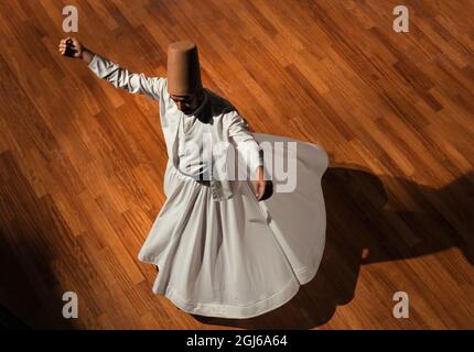 Konya - October 05, 2021: Whirling Dervish | Semazen performing Sama ritual on stage. Dance of Dervishes is a kind of meditating on God through music Stock Photo