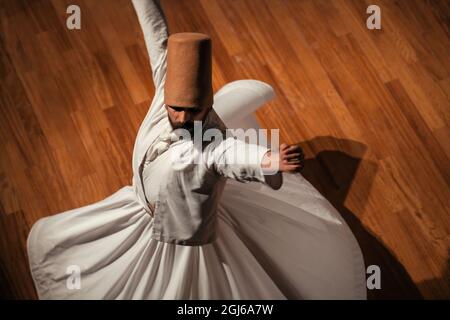 Konya - October 05, 2021: Whirling Dervish | Semazen performing Sama ritual on stage. Dance of Dervishes is a kind of meditating on God through music Stock Photo