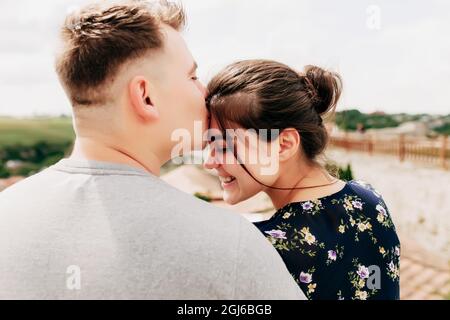 Young Caucasian loving mature couple relaxing outdoor, smiling, hugging, kissing Stock Photo