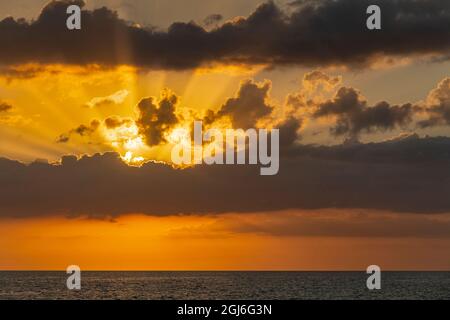 Sunset in clouds over ocean La Boca, Cuba Stock Photo