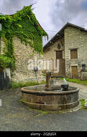 Characteristic fountain with basin in the square of the old medieval village of Crémieu. Crémieu, Auvergne-Rhône-Alpes region, France Stock Photo