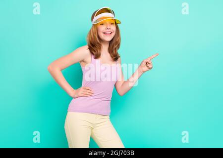 Photo portrait girl smiling cheerful wearing cap headband showing copyspace isolated vivid teal color background Stock Photo