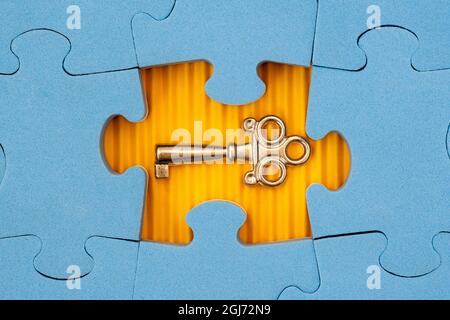 Find key to success, business opportunity or solution. Blue jigsaw puzzle with small key. Stock Photo