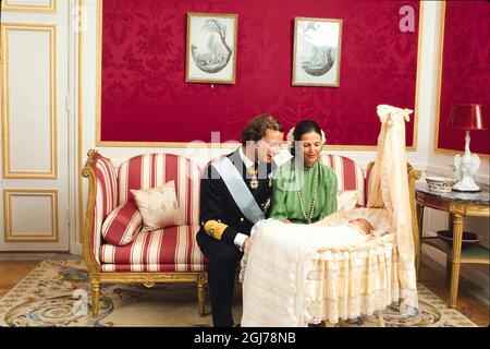 STOCKHOLM FILE 1977-09-27  Princess Victoria lying in the cradle, dressed in a christening gown and admired by her parents King Carl XVI Gustaf and Queen Silvia at the Royal Palace in Stockholm September 27, 1977 after the princess christening in the Palace church. Photo Clas-Goran Carlsson / SCANPIX code 217  Stock Photo