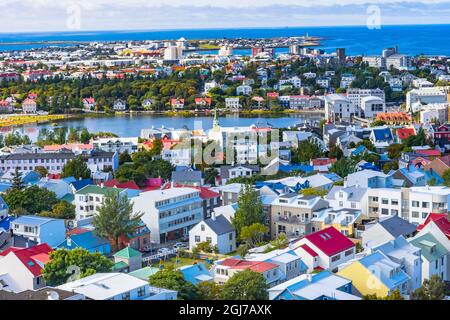Small Tjornin Lake blue Ocean Sea Colorful blue red white green Houses Streets, Reykjavik, Iceland.