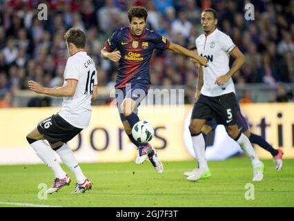 Barcelona's Cesc Fabregas pass Manchester United's Michael Carrick (left) and Rio Ferdinand during the Wednesday Aug. 8, 2012 friendly match between Barcelona FC and Manchester United at Ullevi soccer arena in Goteborg.     Stock Photo