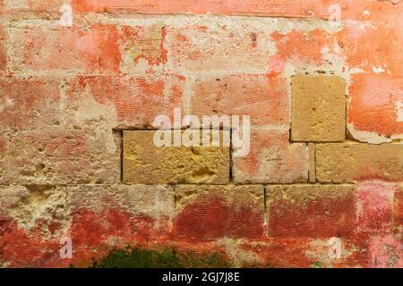Detail of a weathered red and orange stone wall. Stock Photo