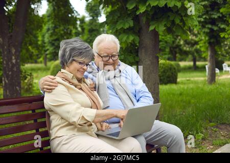 An elderly couple, a man and a woman of European appearance, are relaxing in the park Stock Photo