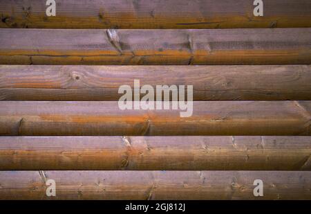 The wall is made of homogeneous wooden logs. Stock Photo