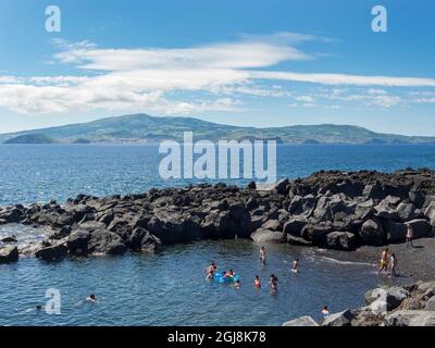 Beach in lava flow near Criacao Velha, Faial island in the background. Pico Island, an island in the Azores in the Atlantic Ocean. (Editorial Use Only Stock Photo