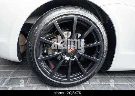 Ukraine, Odessa September 8 - 2021: A cast disc in black rim and a brand sign in the center for a Porsche Boxter with perforated brakes. Porsche alloy wheel with Michelin tires. Stock Photo